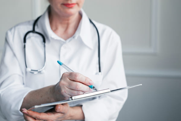 врач заполняет документы перед спуском больного в скорую помощь